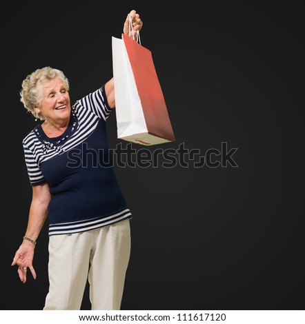 Happy Senior Woman Looking At Shopping Bags Isolated Over Black Background