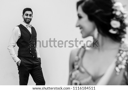 Black and white picture of Hindu bride and groom standing apart outside