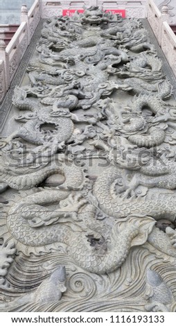 Dragon embossed sculpture. The sign in thai mean " Do not throw coins in the pond."
