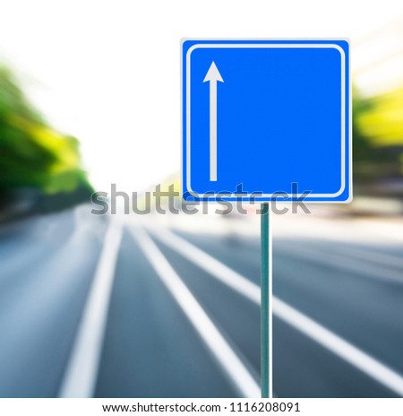 Template, blank, clean blue road sign with arrow and blurred speedy background. Copy space.