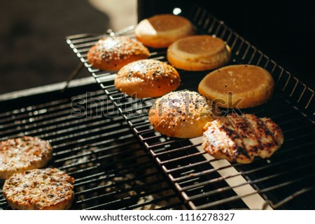 Buns for hamburgers with sesame, grilled meatballs. Beautiful solar picture.