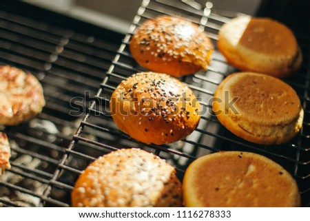 Buns for hamburgers with sesame seeds on the grill. Beautiful solar picture.
