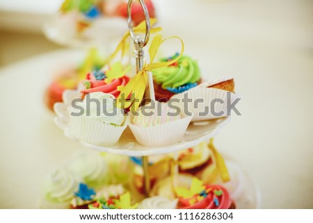 candy bar buffet with cake-stand design for luxury wedding or birthday. decorative dessert for kids party or event.Toned image. Selective focus. cupcake with sugar flower.Copy space