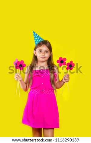 Studio portrait of a little girl wearing a party hat on her birthday.Cute girl Having fun.
