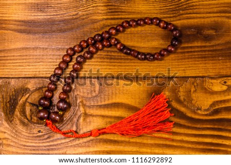 Brown rosary on a rustic wooden table