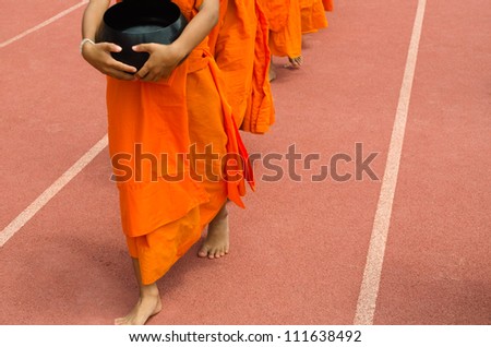 little monks walking on track in stadium