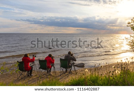 Photographers take pictures of the sunset on Onega lake