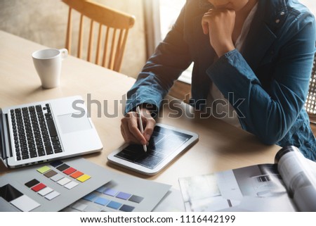 Woman Designer working with sketchinng on digital tablet at her office.