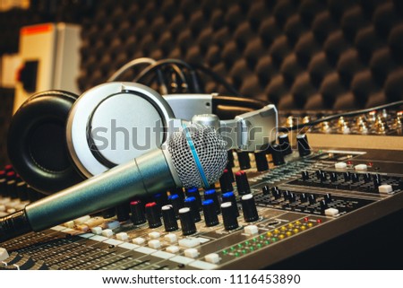 Close up instruments music background concept.Single microphone with headphones on sound mixer board in home recording studio.Free space for creative design text & wording mock up template wallpaper.