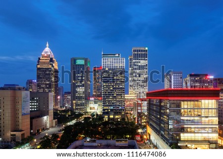 Nightscape of Downtown Taipei, vibrant capital city of Taiwan, with a skyline of high-rise office towers & shopping malls in XinYi Commercial District and neon lights dazzling under blue twilight sky