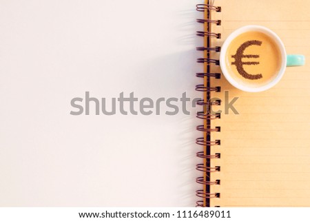 cup of coffee cappuccino with a picture of a Euro sign from cinnamon on milk foam