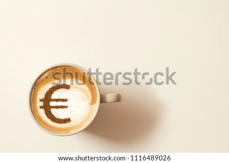 cup of coffee cappuccino with a picture of a Euro sign from cinnamon on milk foam