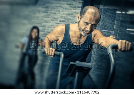Man on exercise bike training for endurance and cardio.  Copyspace for words.