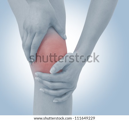 Acute pain in a woman  knee. Female holding hand to spot of knee-aches. Concept photo with Color Enhanced blue skin with read spot indicating location of the pain.