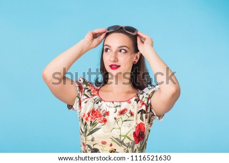 Confident girl smiling to camera. Portrait of woman over blue background
