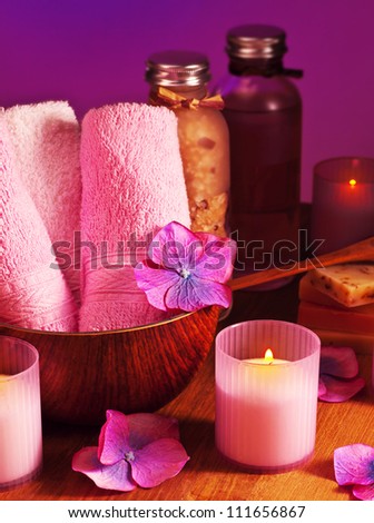 Photo of bath accessories on wooden table over purple background, picture of spa candles, image of alternative treatment items, day spa concept, pink still life, health and beauty care