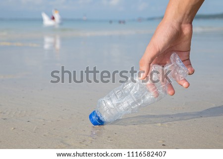 Hand picking up plastic bottle cleaning on the beach.
Campaign to clean.Save the world