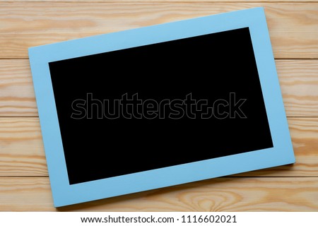 Frame with blank black space  isolated on wooden background, with path .