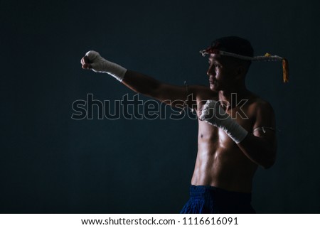 Muay Thai, Thai boxing standing ready to fight action.Dark background.