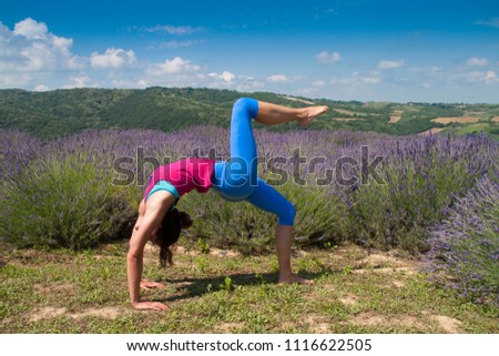 Young woman practicing yoga in lavender field. Health lifestyle concept