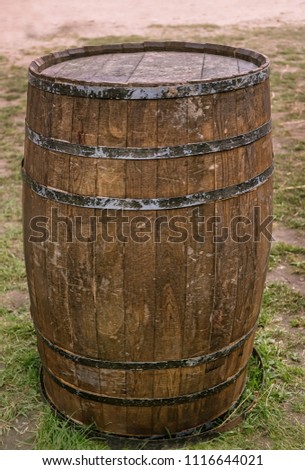 Old retro big wooden barrel with metal hoops for wine or beer on grass natural background. element for design