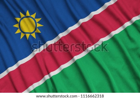 Namibia flag  is depicted on a sports cloth fabric with many folds. Sport team banner