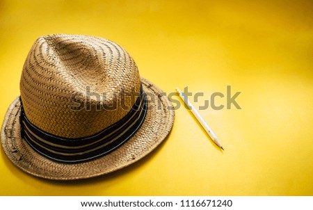 Hat wicker and pencil on yellow background color style vintage