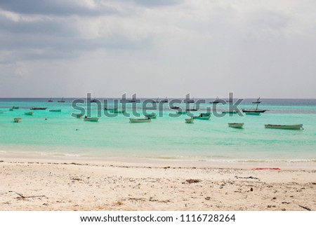 Fisherman boats in the turquoise water sea on Kizimkazi beach, Zanzibar, Tanzania