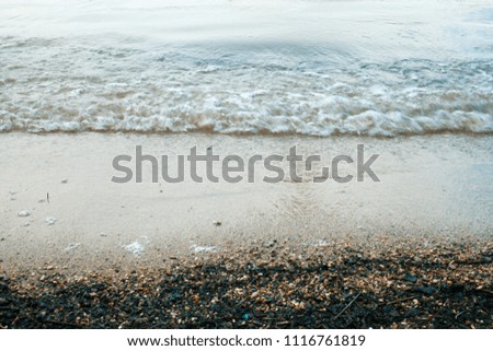 Waves on the sandy beach of the lake before the rain. Background image. Vintage effect.