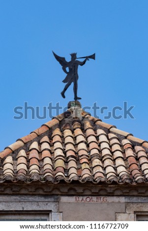 Interesting weathercock on the roof as human figure with trumpet