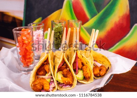 Shrimp tacos closed with a wooden hook.