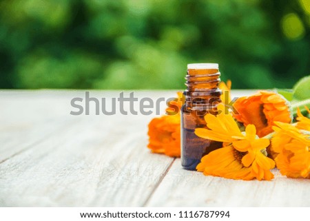 calendula extract and flowers in a small bottle. Selective focus. 