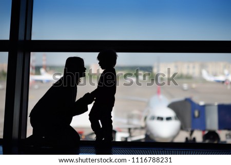Young woman with little boy having fun at the international airport. Mother with her cute little son waiting boarding. Family travel or immigration concept