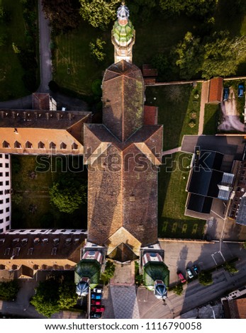 Soaring majestic church Saint Maurice in little french village Ebersmunster. Aerial drone view. Alsace. France. Royalty-Free Stock Photo #1116790058