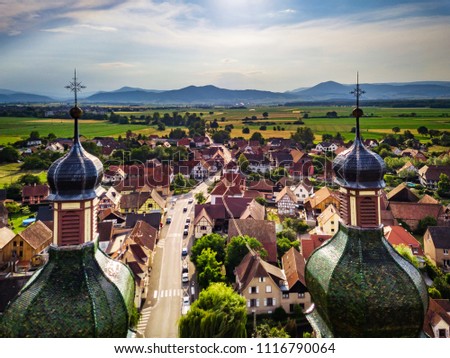 Soaring majestic church Saint Maurice in little french village Ebersmunster. Aerial drone view. Alsace. France. Royalty-Free Stock Photo #1116790064