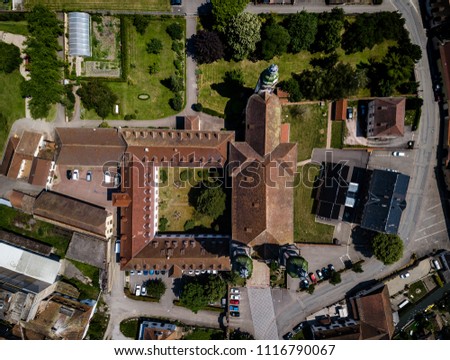 Soaring majestic church Saint Maurice in little french village Ebersmunster. Aerial drone view. Alsace. France. Royalty-Free Stock Photo #1116790067