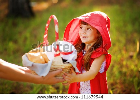 mother hands over to the daughter a basket with food.  the fairy tale " Red Riding Hood"