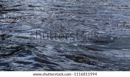 background - river water with waves and whirlpools on a cloudy day