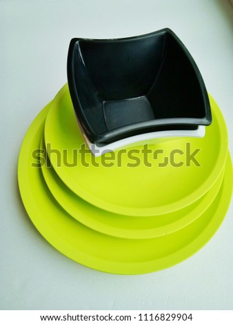 Plate with bowl is colorful on a white table.