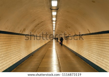 Long exposure photograph of people walking under the Schelde river inside the pedestrian tunnel Voetgangerstunnel in the city of Antwerp, Belgium.
