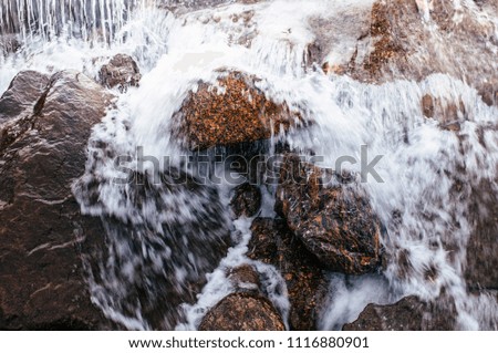 Close up details of Tropical river flowing rapid water and rocks landscape, slow shutter speed