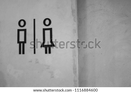 Men and women toilet signs on wall, black and white