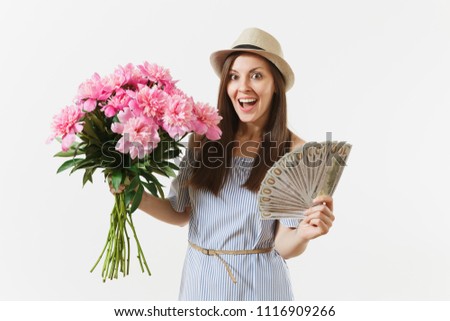 Young pretty happy woman in blue dress, hat holding bundle of dollars, cash money, bouquet of beautiful pink peonies flowers isolated on white background. Business, delivery, online shopping concept