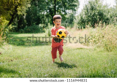 Cute little kid, playing football together, summertime. Children playing soccer outdoor