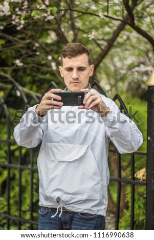 a guy of European appearance photographs on a black phone