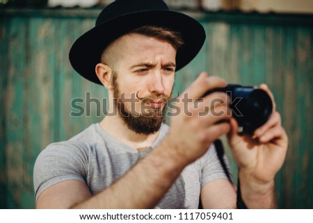 Fashion photography, people,style, hobby, technology concept. Hipster man photographer taking pictures using modern camera.