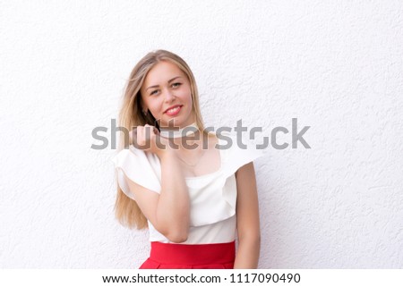 Fashionable happy girl posing on white textured background. Woman dressed in white blouse and red skirt. Close up portrait photo with copy space. Pretty, calm, attractive, smiling girl.