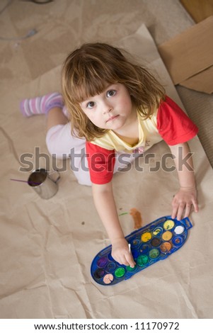 little girl drawing on a big sheet of brown paper