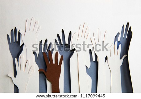 Humans hands raised up celebrating togetherness, teamwork and support. Paper made background  Royalty-Free Stock Photo #1117099445