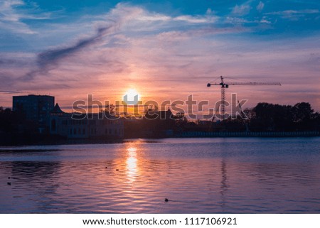Beautiful landscape of sunset over the lake. Sky is reflecting in the water. Evening on the Upper lake in Kaliningrad, Russia.